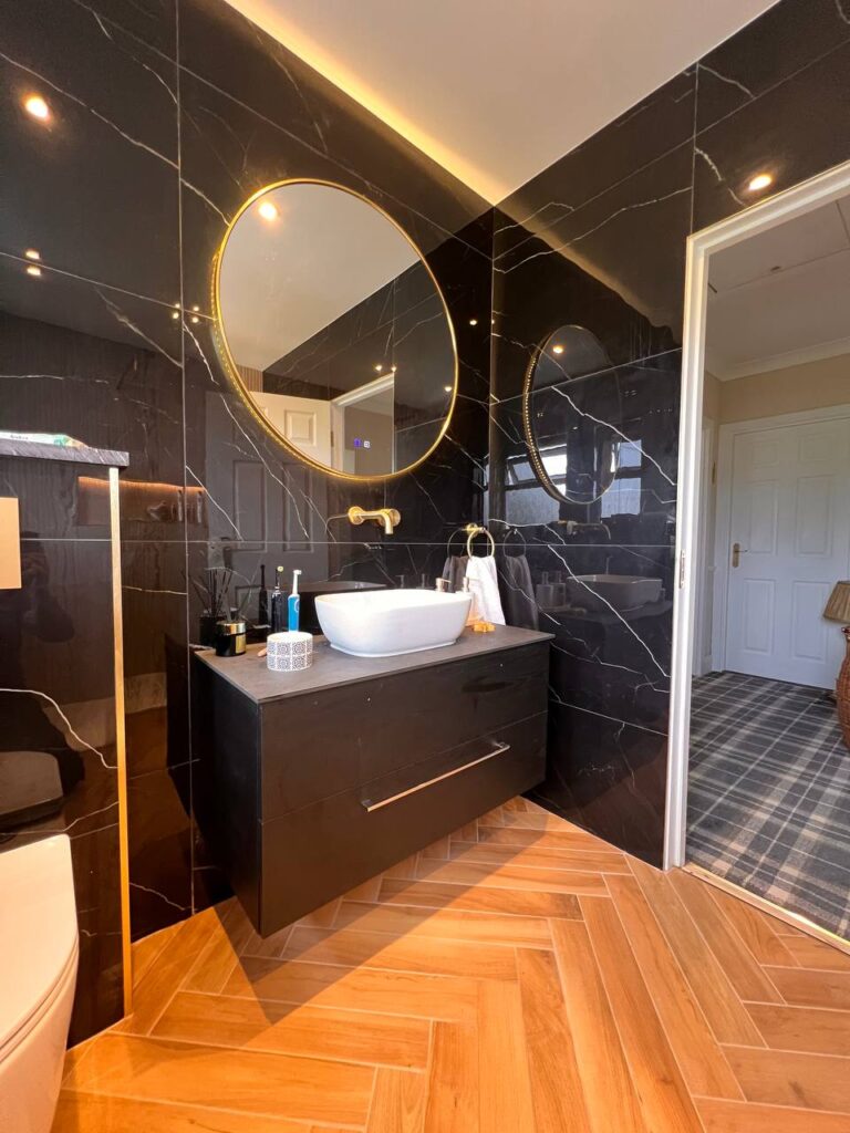 An image showing a bathroom interior with wooden floor and tiled walls