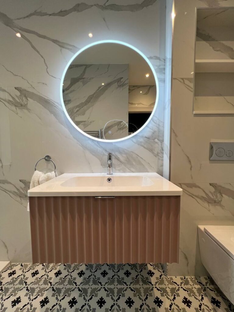 An image of a mirror and sink inside the bathroom